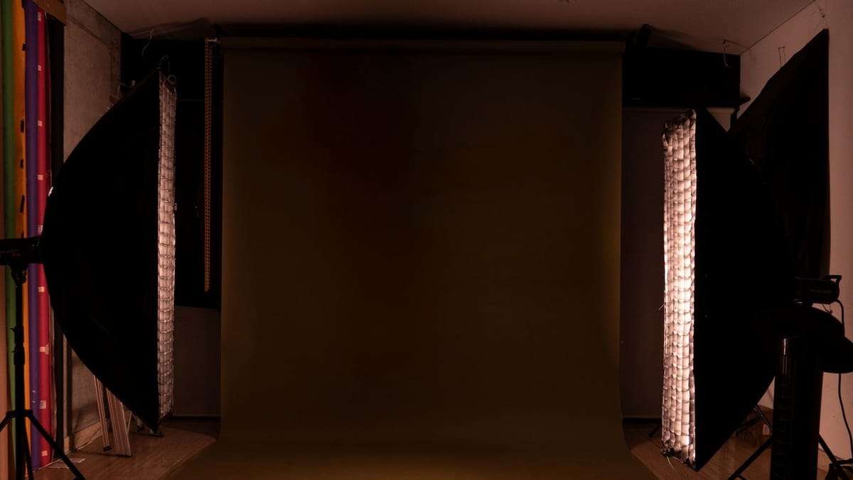 A sleek and modern photography studio setup featuring a mocha backdrop and professional lighting equipment.